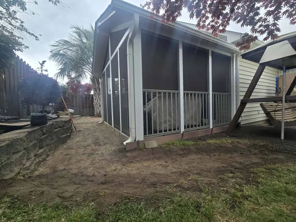 Before: bare, eroded dirt beside a home after heavy rain