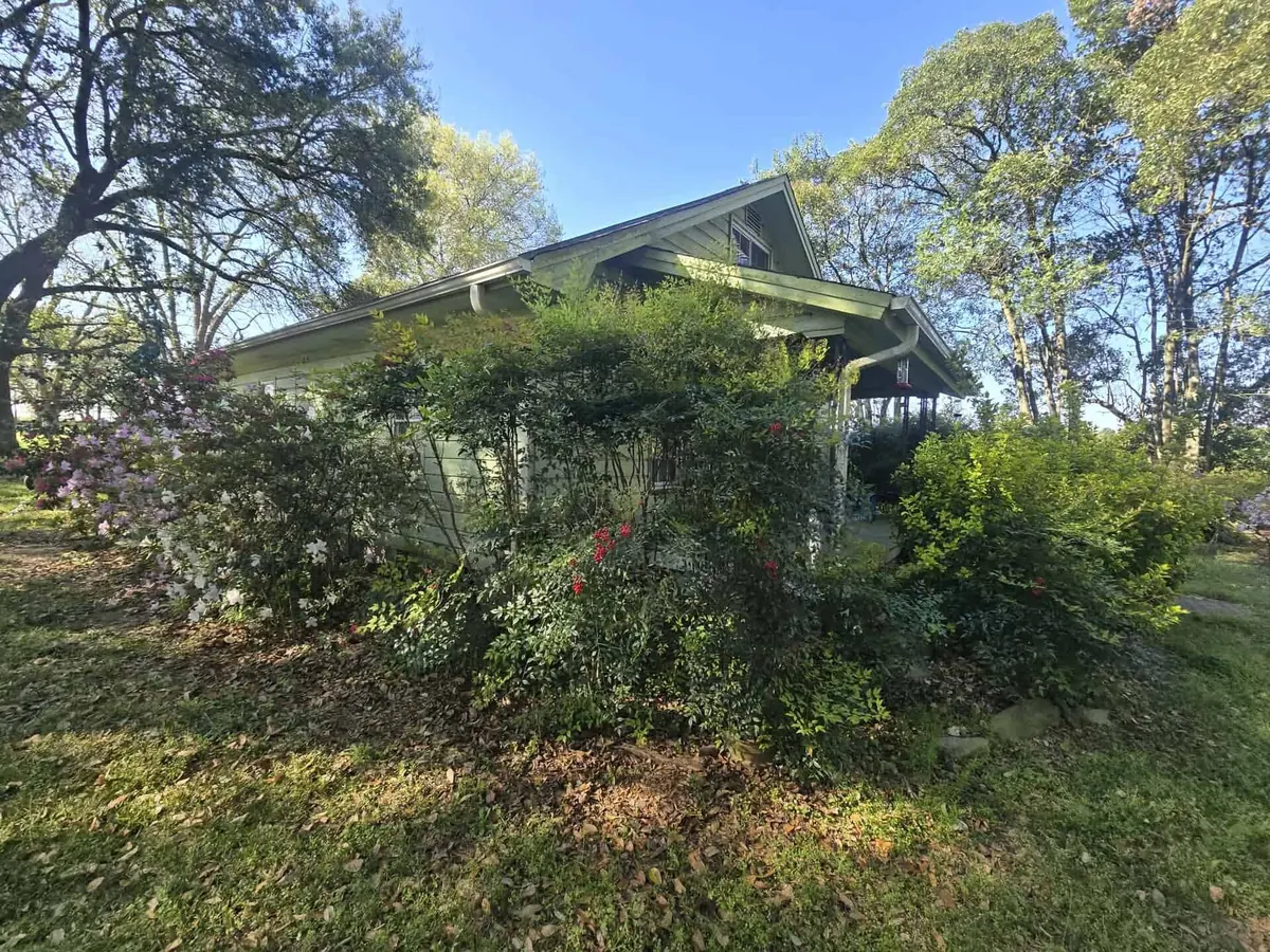 Before: overgrown shrubs and weeds in front of the same home