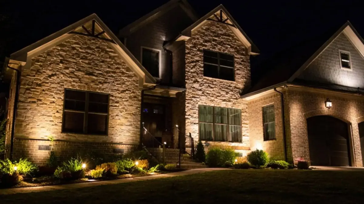 Stone home with uplighting on the facade and path lights at night