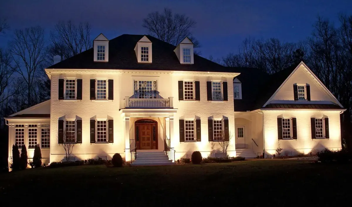 Two-story home lit up at night with H2Os landscape lighting